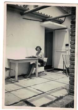Photo image of Margo Williams at a typewriter in Africa